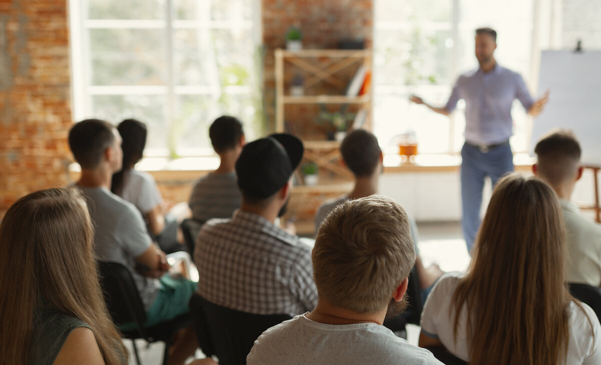 Male speaker giving presentation in hall at university workshop